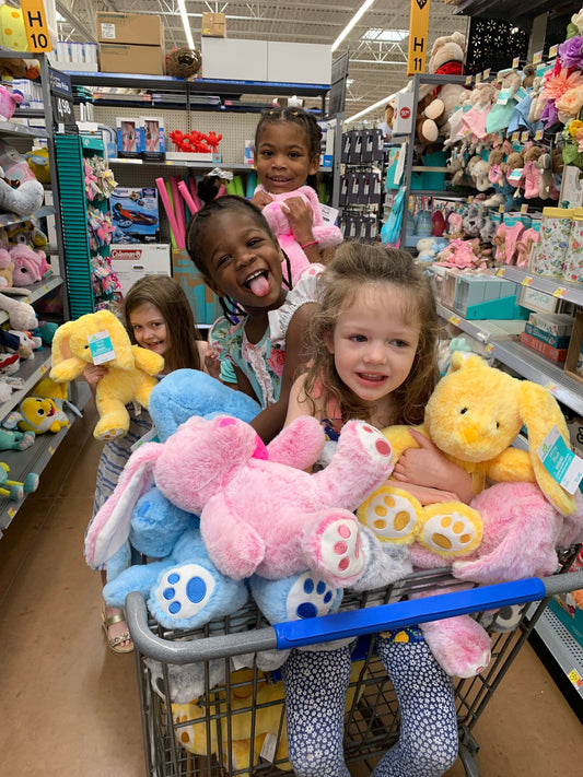 Young girls in a basket full of stuff bunnies