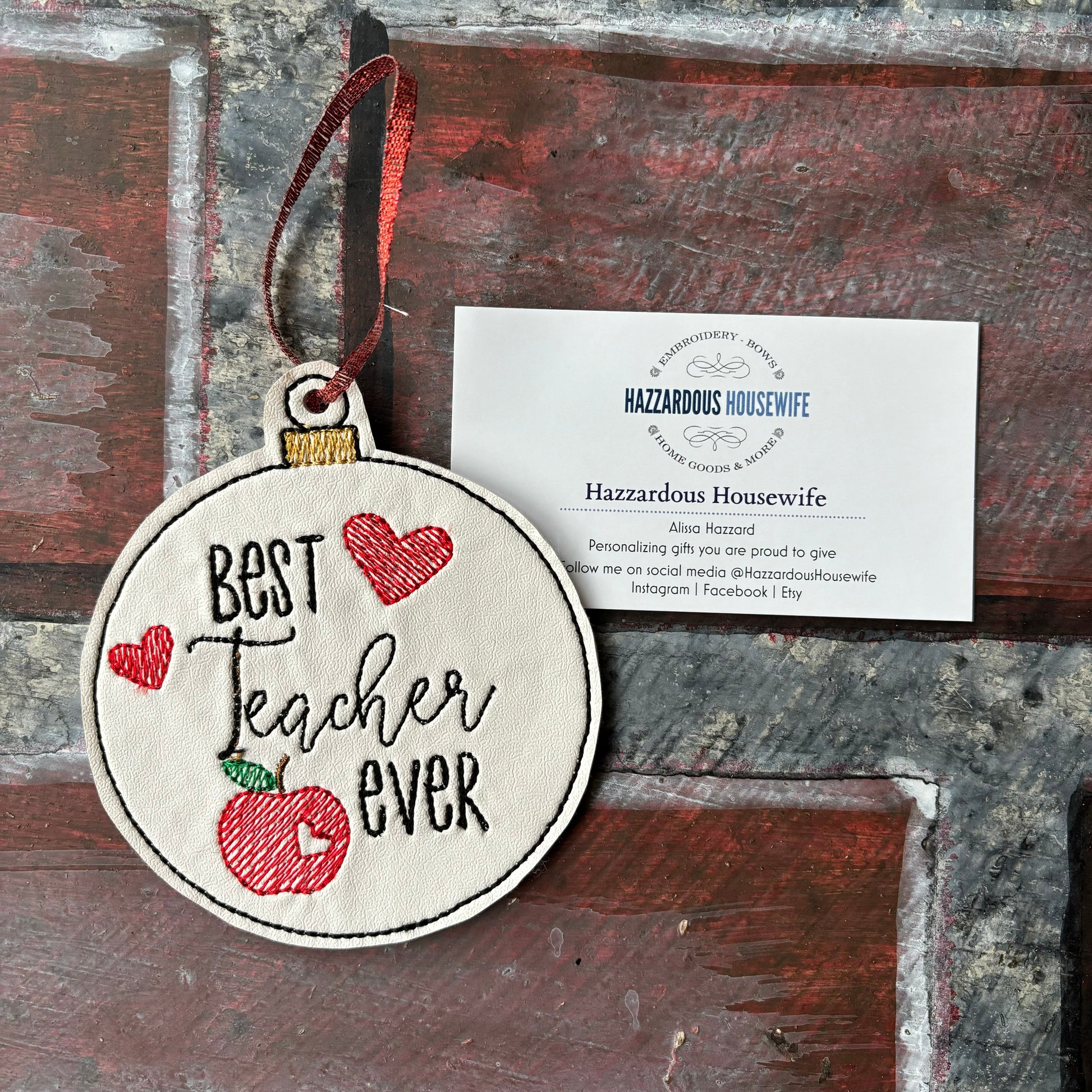 Decorative tag with 'Best Teacher Ever' text and an apple design, hanging on a wooden surface.