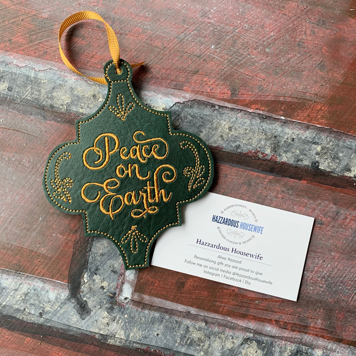 Decorative ornament with 'Peace on Earth' text on a rustic wooden surface