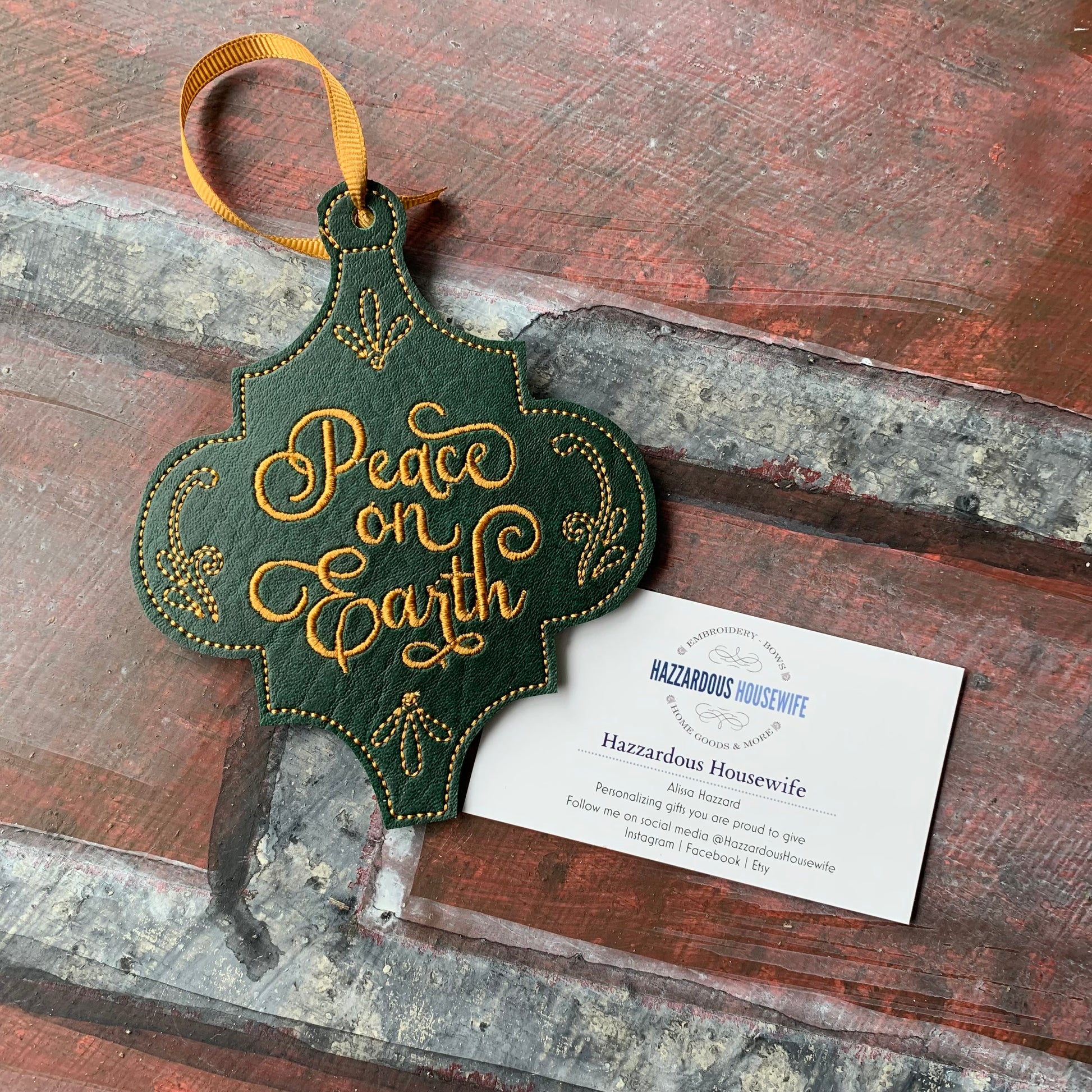 Decorative ornament with 'Peace on Earth' text on a rustic wooden surface