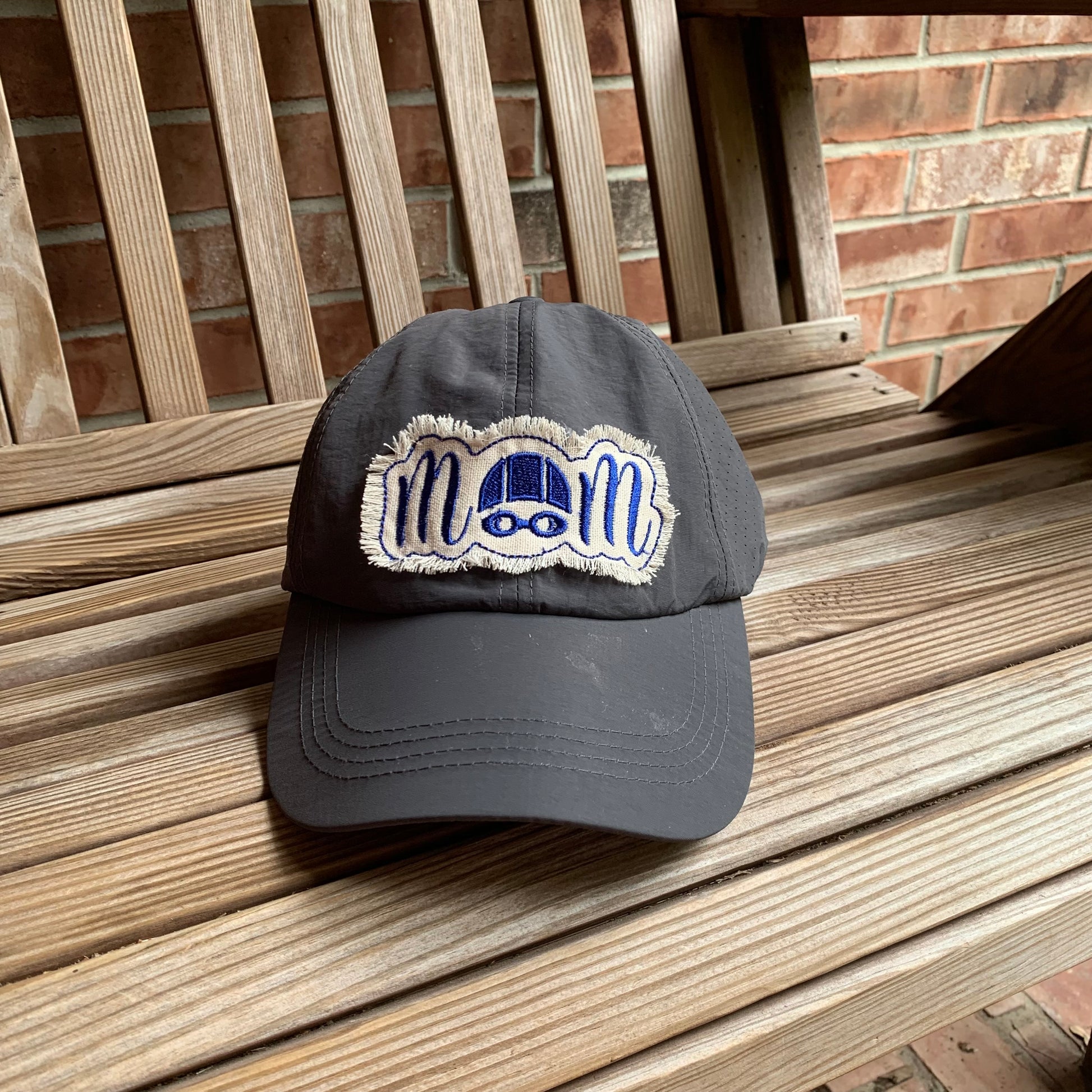 Gray cap with a logo on a wooden bench against a brick wall