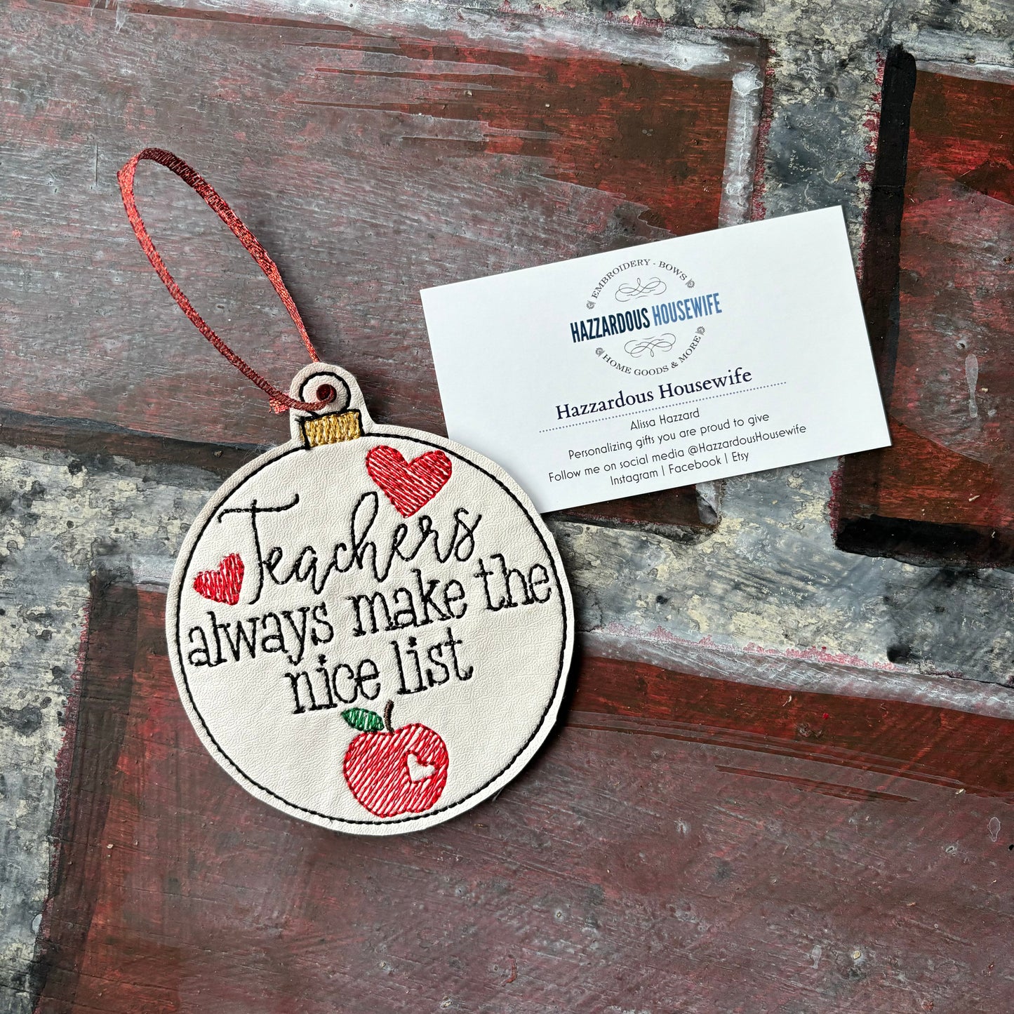 Decorative ornament with 'Teachers always make the nice list' text on a wooden surface.