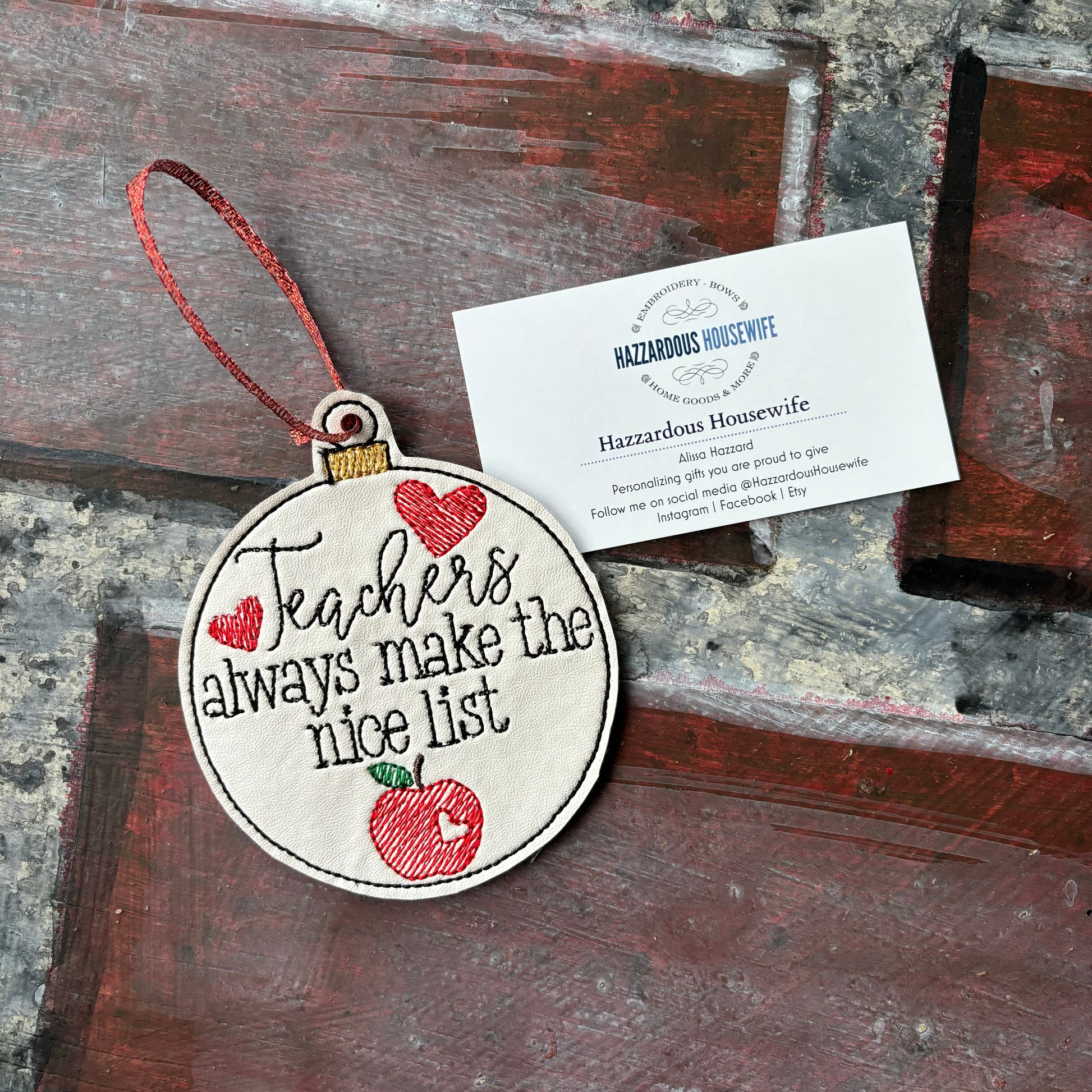 Decorative ornament with 'Teachers always make the nice list' text on a wooden surface.