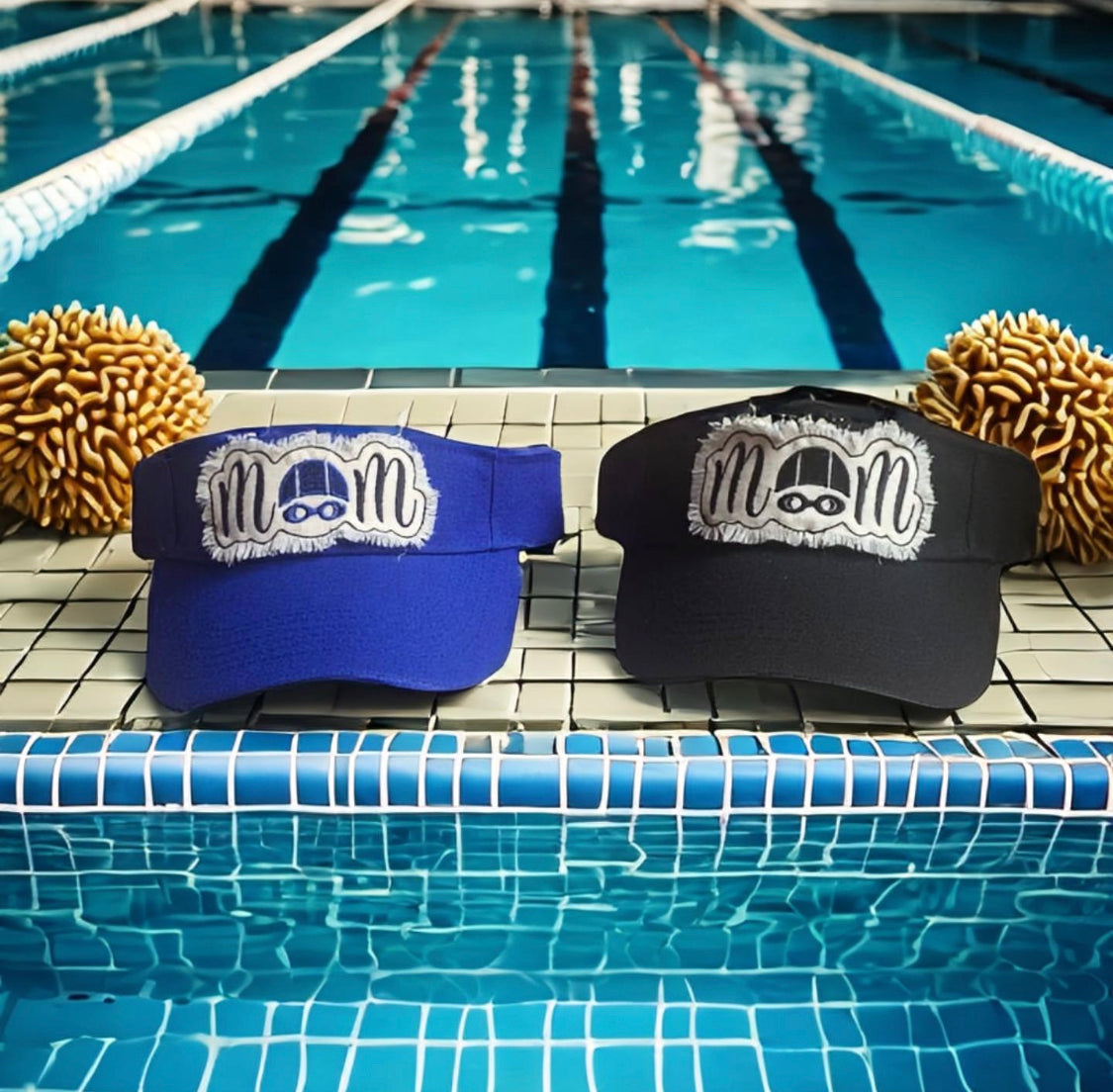 Two visors with a mom logo on a pool deck.  The O in mom is a swim cap and goggle