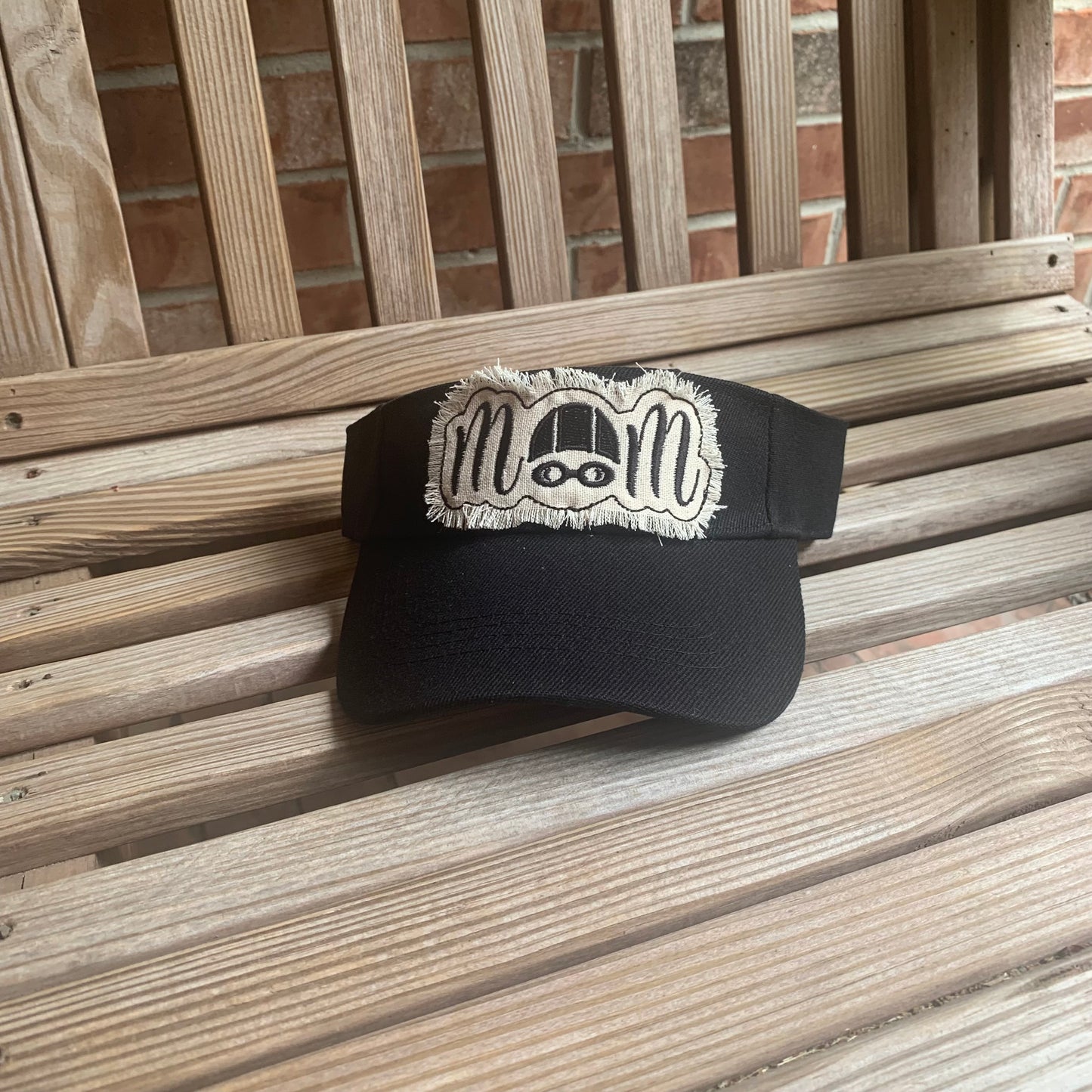 Black cap with white logo on a wooden surface