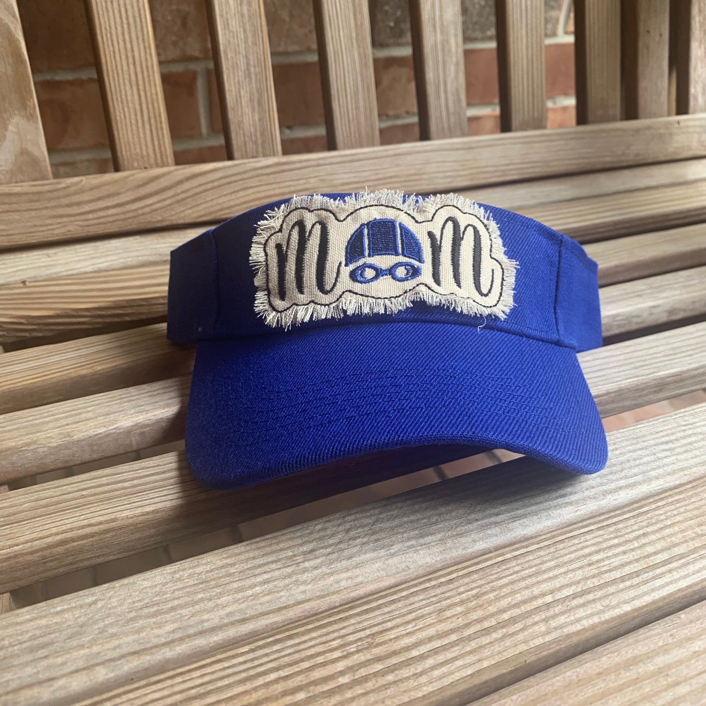Blue visor with a white patch on a wooden surface