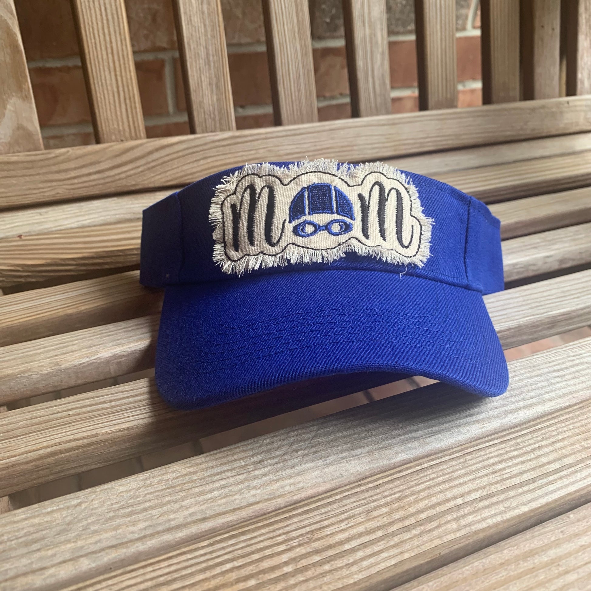Blue visor with a white patch on a wooden surface