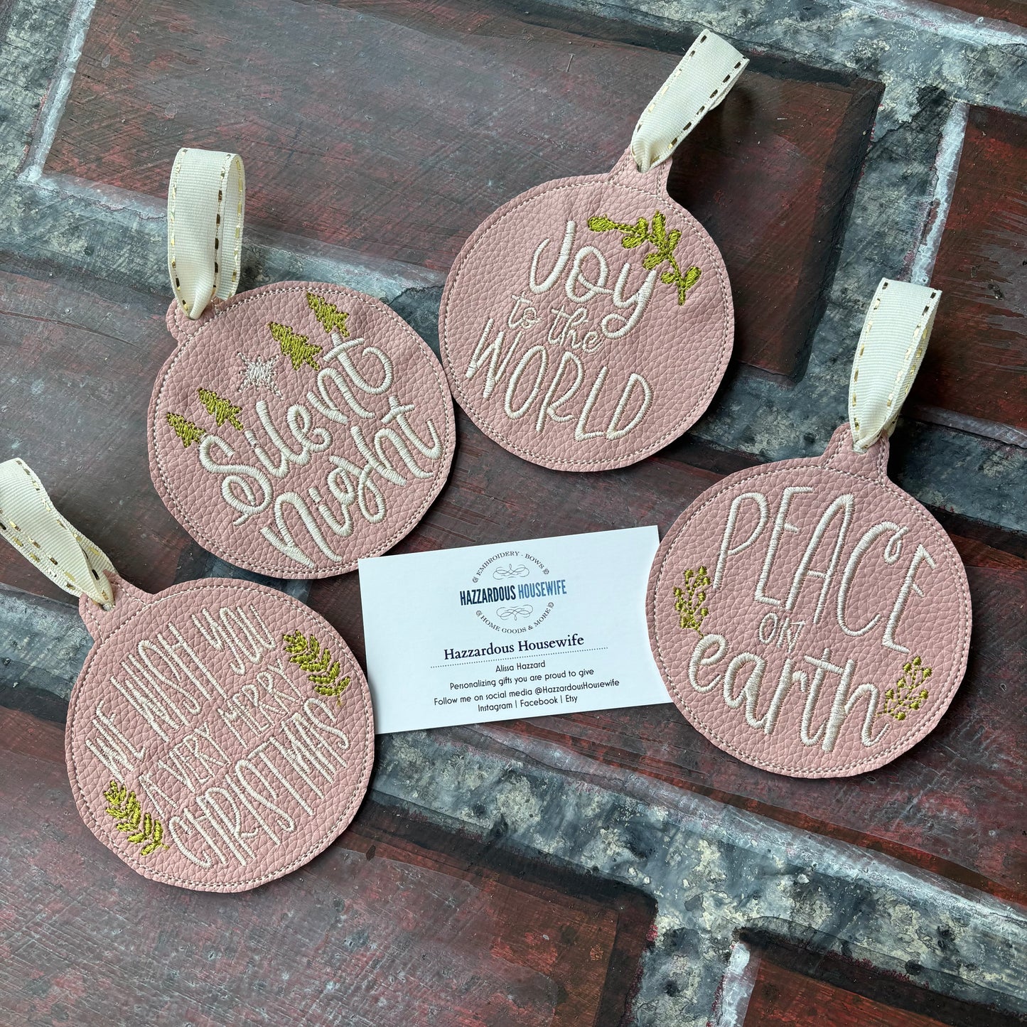 Set of round pink ornaments with text and a business card on a rustic wooden surface